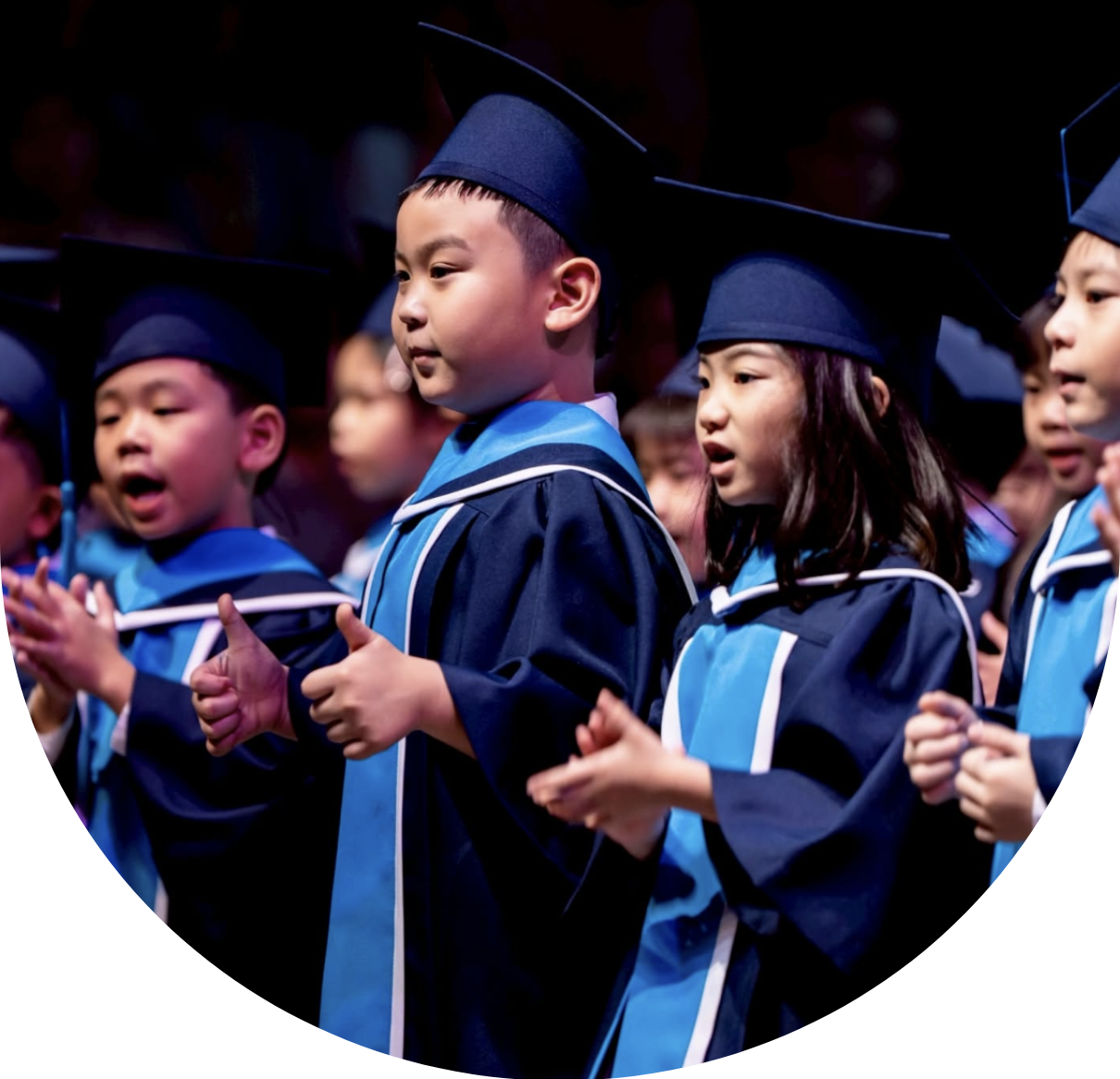 Young BASIS students in graduation gowns applauding